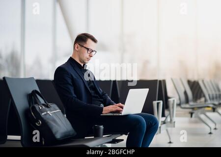 Close up of young freelance business man hands typing on a laptop keyboard while working remotely. Stock Photo