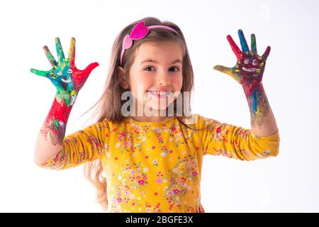 Little happy student girl showing painted hands - childhood and drawing concept, education and art. Stock Photo