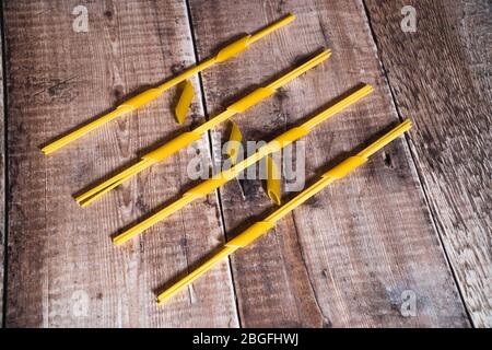 Spaghetti fed through penne pasta and framed on wooden surface Stock Photo