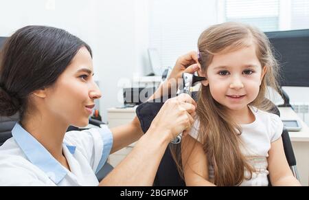 ENT doctor doing an ear exam with otoscope to little girl. Hearing clinic Stock Photo