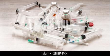 Many medicine bottles, ampules, vials, injection needles and syringes stack together on white background. Stock Photo