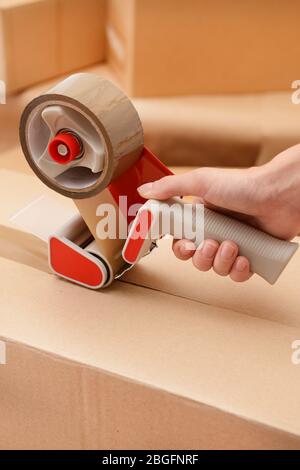 Packaging parcels with dispenser close-up Stock Photo