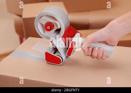 Packaging parcels with dispenser close-up Stock Photo