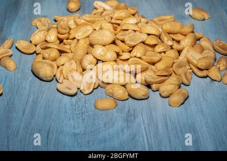 many peeled peanuts on blue color background Stock Photo
