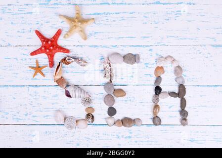 Word sea made from sea shells and stones on wooden background Stock Photo