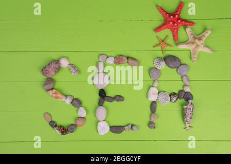 Word sea made from sea shells and stones on wooden background Stock Photo