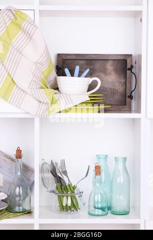 Kitchen utensils and tableware on beautiful white shelves Stock Photo