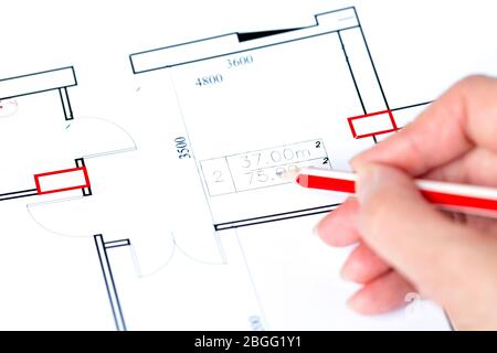 Macro close up of quantity surveyors hand reviewing technical drawing. Architect working on blueprint Stock Photo