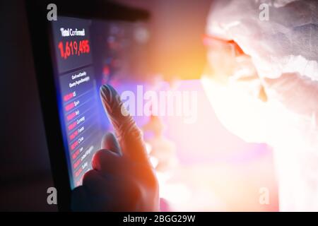 Analysis number of infected people in China and world from virus, doctor in protective chemical suit with respirator computer in laboratory Stock Photo