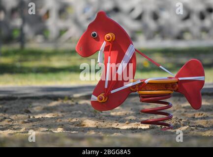 21 April 2020, Brandenburg, Frankfurt (Oder): A small rocking horse in a public playground is cordoned off with a tape because of the Corona crisis. Photo: Patrick Pleul/dpa-Zentralbild/ZB Stock Photo