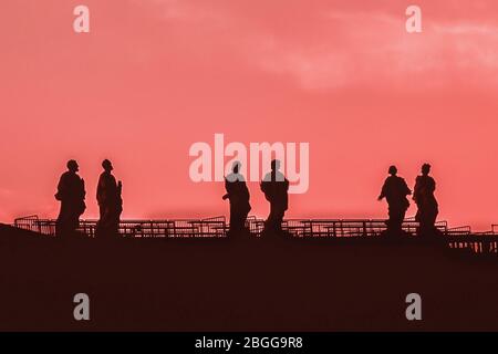 Sculptures of saints in Vatican. Silhouette on the coral color sky background. Details Stock Photo