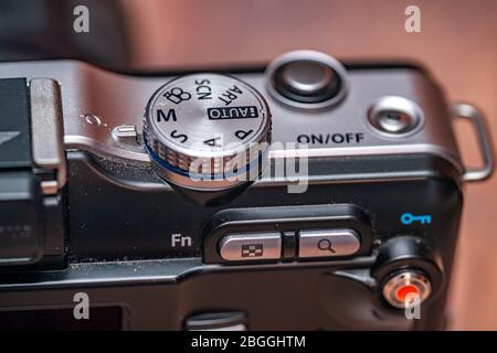 Norwich, Norfolk, UK – April 19 2020. Close up and selective focus on the mode dial on the back of a classic Olympus PEN mirrorless digital camera Stock Photo