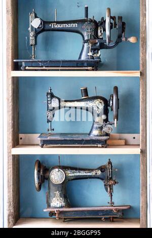 Krakow, Poland. September 22, 2018. Three vintage sewing machines on a blue wall background Stock Photo