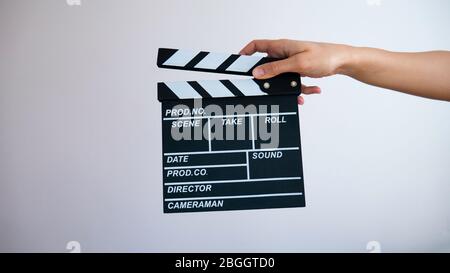 Close up female hold in hand wooden black clapperboard isolated on gray background. Stock Photo