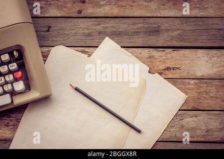 Typewriter, pensil and paper on wooden background. Literature, author creative writing workshop and journalism concept.