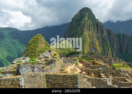 Close up of Inca Walls in the Inca Ruin of Machu Picchu with the Huayna Picchu Peak in the background, Cusco, Peru. Stock Photo