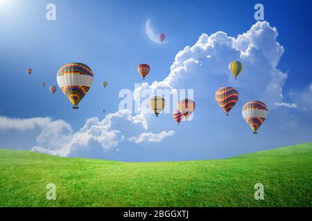 Idyllic heavenly background - colorful hot air balloons rise up into blue  sky above white clouds and green field to new moon. Dream come true concept  Stock Photo - Alamy