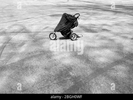Baby Stroller in Empty Parking Lot Stock Photo