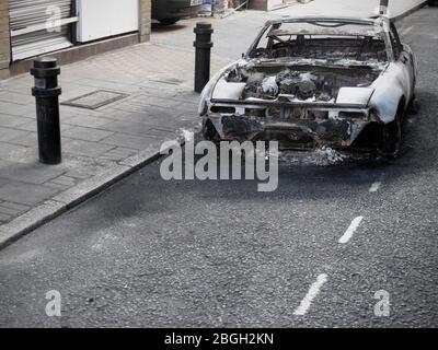 Burnt out Car on Road Stock Photo