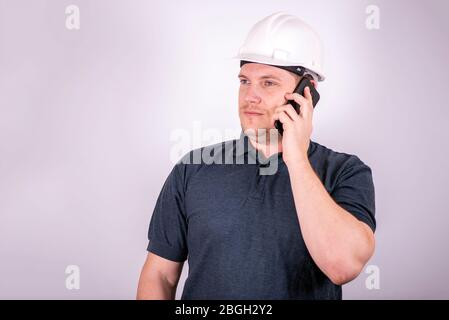 white male engineer in a white hard hat Stock Photo