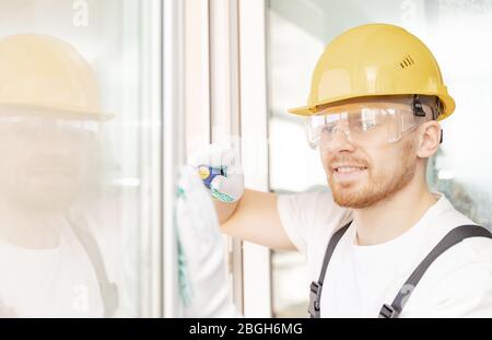 Worker in installing white plastic upvc window on house Stock Photo