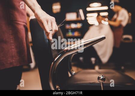 Barbershop Close-up of barber holds clip-on hair clipper Stock Photo