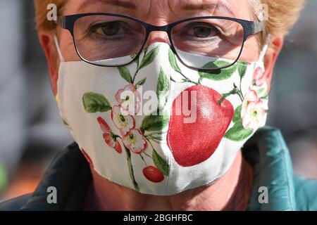 Munich, Deutschland. 21st Apr, 2020. Mask requirement in Bavaria in all shops and in local public transport. Masks in all variations are now part of everyday life in the times of Corona. A self-sewn, reusable face mask, face mask, mouth-nose protection of a woman shows floral patterns and a red cherry. | usage worldwide Credit: dpa/Alamy Live News Stock Photo