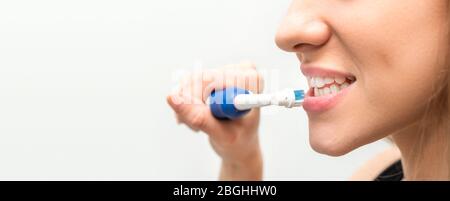 Beautiful young woman using toothbrush. Dental health background. Stock Photo