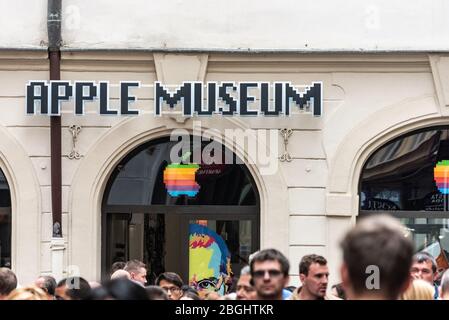 The front of Apple computer museum in Prague.  Macintosh Founder Steve Jobs drawing watching forward, the group of people, tourists on the street. Stock Photo