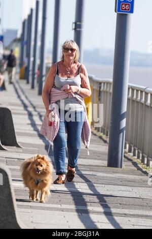 Liverpool, UK. 21st Apr, 2020. A woman is seen walking her dog alongside the Royal Albert Dock in Liverpool. The British Government imposed nationwide lockdown to minimise the spread of coronavirus disease COVID-19. Photo Credit: Ioannis Alexopoulos/Alamy Live News Stock Photo