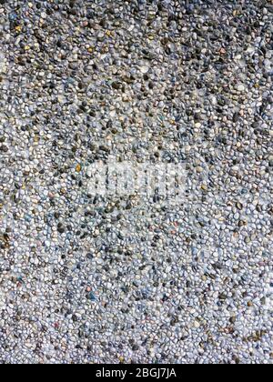Abstract background pattern of colored pebbles in cement wall. Stock Photo