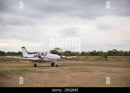 Small plane on bush runway in remote safari camp in Busanga Plains, Kafue National Park, North Western Province, Zambia. Stock Photo