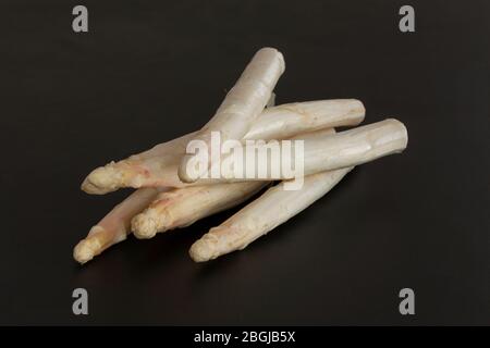 Raw organic white asparagus spears. Fresh vegetables on black background. Stock Photo