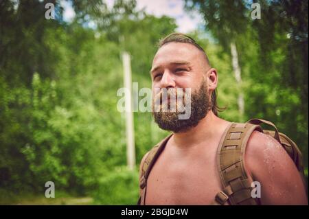 Portrait of a bearded tourist man with a backpack. Stock Photo