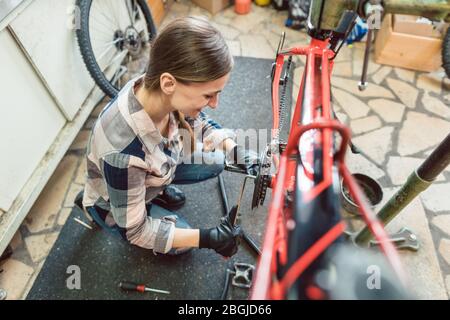Bike technician in her workshop working on bicycle Stock Photo