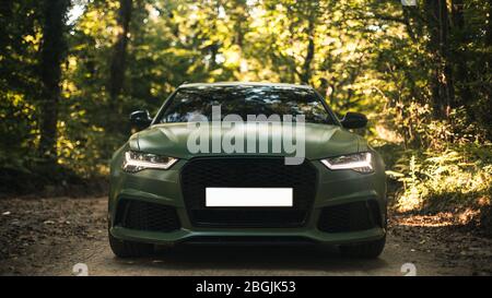 Black dusty sedan parked in the deep forest in the shadow Stock Photo ...