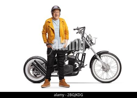 Mature biker in a yellow leather jacket smiling and posing with a chopper motorbike isolated on white background Stock Photo