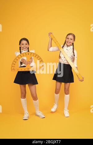 School students study geometry. Pupil school girls big rulers. School knowledge. Explore world with math. Discover mathematics patterns. Mathematical theory combining algebraic and geometric methods. Stock Photo