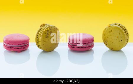A french sweet delicacy, macaroons variety closeup. Macaroon colourful, different types of macaroons on a white and yellow background Stock Photo