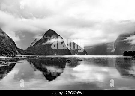 Dramatic scene and reflections of Mitre Peak at Milford Sound Fiordland New Zealand in the rain mist and low cloud Stock Photo