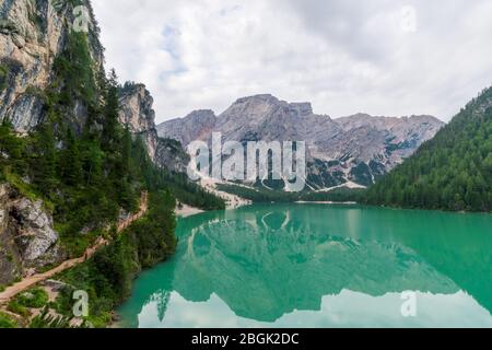 View of Lake Braies and a path that runs alongside it, in the background the Seekofel or Croda del Becco Stock Photo