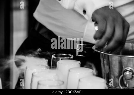 Foam and smoke coming out of the champagne glasses in close up Stock Photo