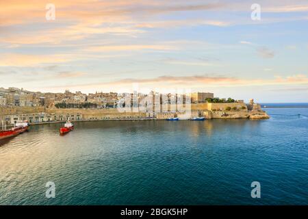 View of the skyline of the ancient walled city of Valletta Malta from a cruise ship in the Grand Harbor of the Mediterranean Island as the sun sets. Stock Photo