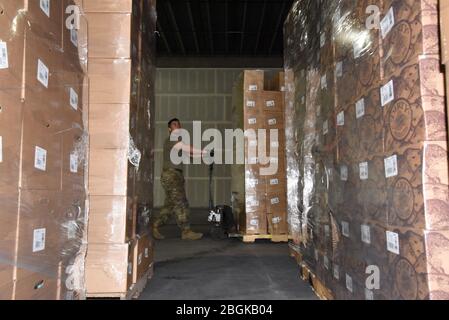 Staff Sgt. Alexis Yanez Valdez utilizes a hand pallet truck to move donated food from a truck into a local warehouse March 30, 2020, Phoenix. The Arizona National Guard activated more than 700 Arizona Citizen-Soldiers and Airmen to support grocery stores, food banks and other community needs during this state of emergency response (U.S. Air National Guard photo by Tech. Sgt. Michael Matkin). Stock Photo