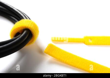yellow velcro cable tie and cable on white Stock Photo