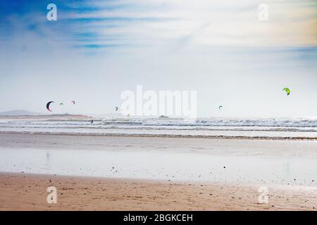 View of the Atlantic Ocean from a Beach in Essaouira Morocco with People Kite Surfing Stock Photo