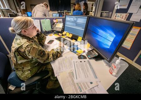 Senior Airman Brooke Tyler, 130th Airlift Wing, West Virginia National Guard (WVNG), assists state partner agencies by manning phone lines at the West Virginia Poison Center, part of the statewide Coronavirus 2019/COVID-19 response efforts, March 19, 2020, in Charleston, West Virginia. The members are answering questions and inquiries from concerned citizens on a hotline established as part of an interagency whole-of-government approach in response to the ongoing pandemic. (U.S. Army National Guard video by Edwin L. Wriston) Brooke Tyler, 130th Airlift Wing, West Virginia National Guard (WVNG) Stock Photo