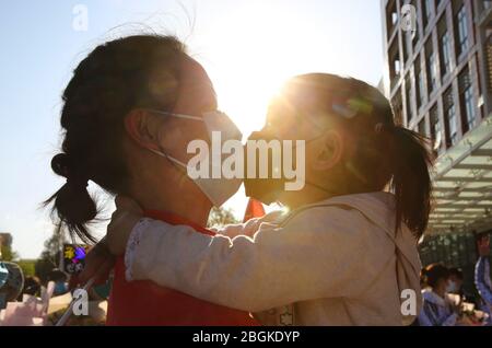Beijing, China. 20th Apr, 2020. Li Peitao, a member of the medical team of Peking University Third Hospital supporting Hubei Province amid the coronavirus outbreak, kisses her daughter before attending a welcome ceremony in Beijing, capital of China, April 20, 2020. Since Jan. 26, the Peking University Third Hospital has successively sent three batches, 137 medical workers to Wuhan. Credit: Yin Gang/Xinhua/Alamy Live News Stock Photo