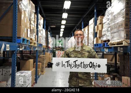 U.S. Army National Guard Soldier, Lt. Stephen Reid, assigned to the Ohio National Guard’s HHC 1-148th Infantry Regiment – 37th Infantry Brigade Combat Team, shares a message of togetherness while serving at the Toledo Northwestern Ohio Food Bank, March 26, 2020. Nearly 400 Ohio National Guard members were activated to provide humanitarian missions in support of COVID-19 relief efforts, continuing The Ohio National Guard’s long history of supporting humanitarian efforts throughout Ohio and the nation. Air National Guard photo by Senior Master Sgt. Beth Holliker. Stock Photo
