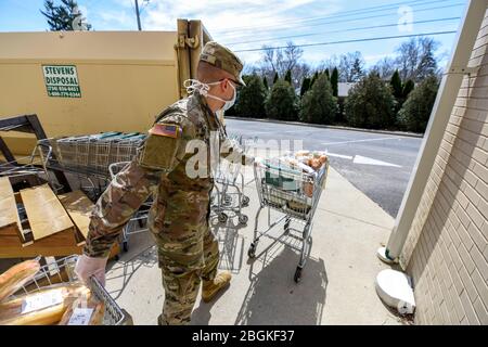 U.S. Army Spc. Isaiah Clark, a Soldier assigned to the Ohio National Guard’s HHC 1-148th Infantry Regiment – 37th Infantry Brigade Combat Team, moves donated items from a store to a Humvee in Toledo, Ohio, April 6, 2020. The food will be taken to the Toledo Northwestern Ohio Food Bank in Toledo, Ohio. More than 500 Ohio National Guard members were activated to provide humanitarian missions in support of COVID-19 relief efforts, continuing the Ohio National Guard’s long history of supporting humanitarian efforts throughout Ohio and the nation.  (U.S. Air National Guard photo by Senior Airman Kr Stock Photo